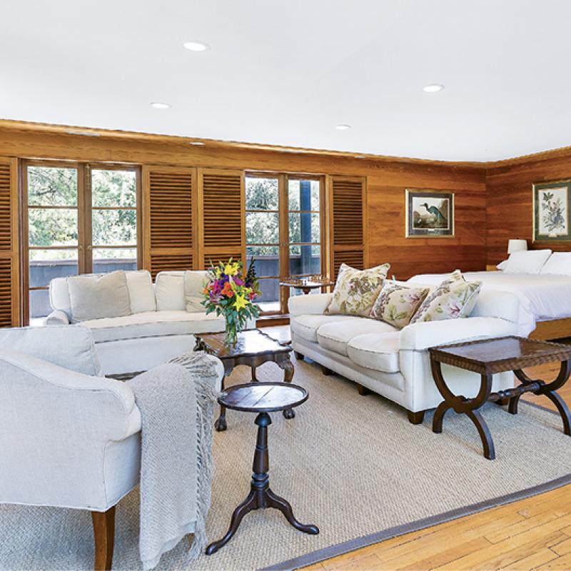 Located on the third floor of The Lodge, the Ashley River Room features cypress paneling, a large seating area, a wood-burning fireplace, and a private wrap-around deck.